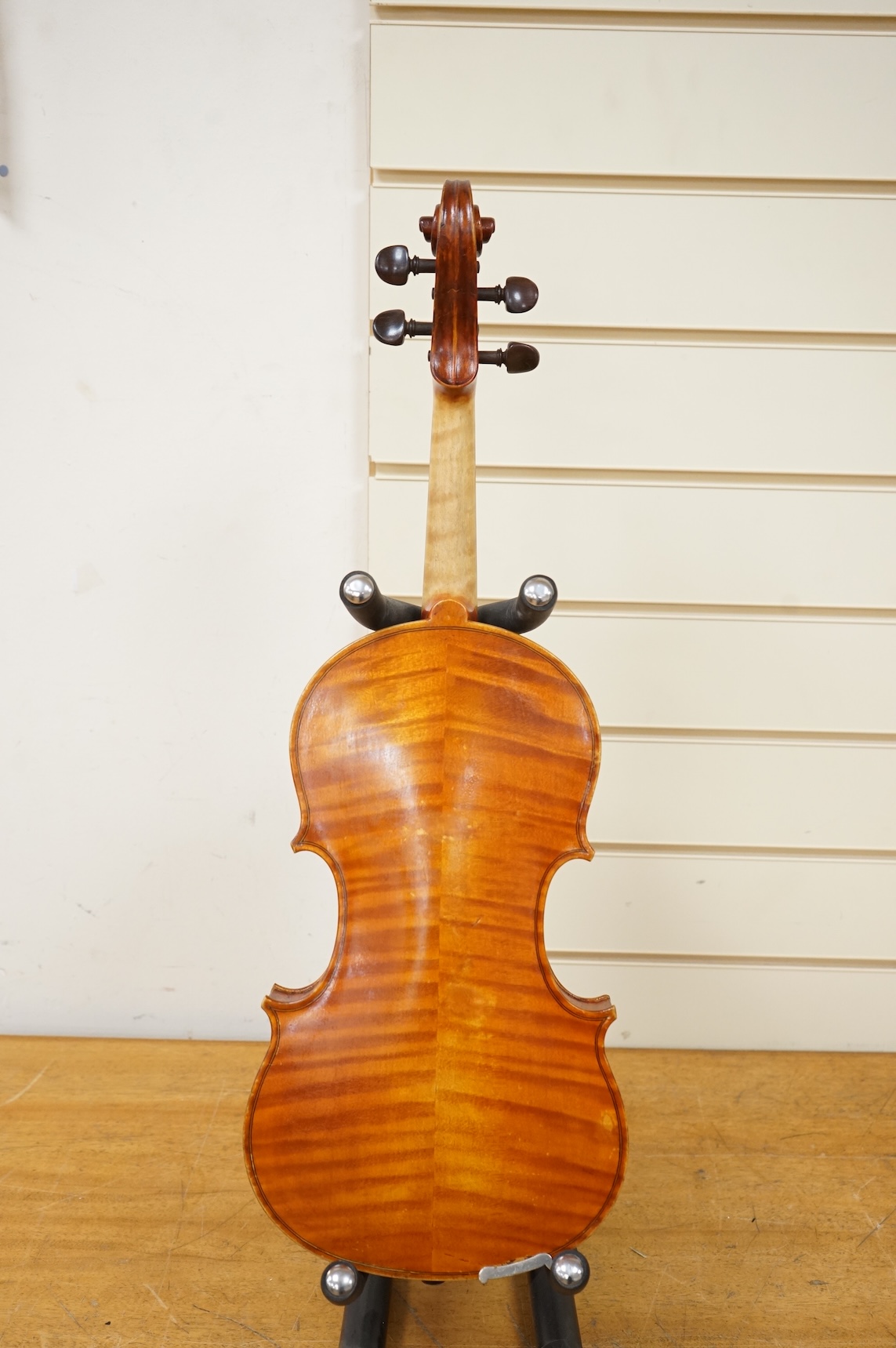 Three violins; a late 19th century German Stradivarius pattern violin, without label, a handmade violin (a.f.), with sound post crack, broken and repaired scroll, etc. and a Maidstone violin body, varnish stripped from t